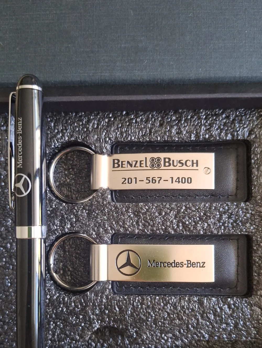 The seMercedes-Benz branded gift set featuring two keychains and a ballpoint pen